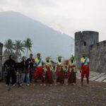Bandanese dancers and musicians performing on Fort Belgica with the Gunung Api volcano behind, Banda Neira