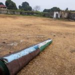 Old painted cannon lying on the grass inside the walls of a Dutch colonial fort, Banda Neira