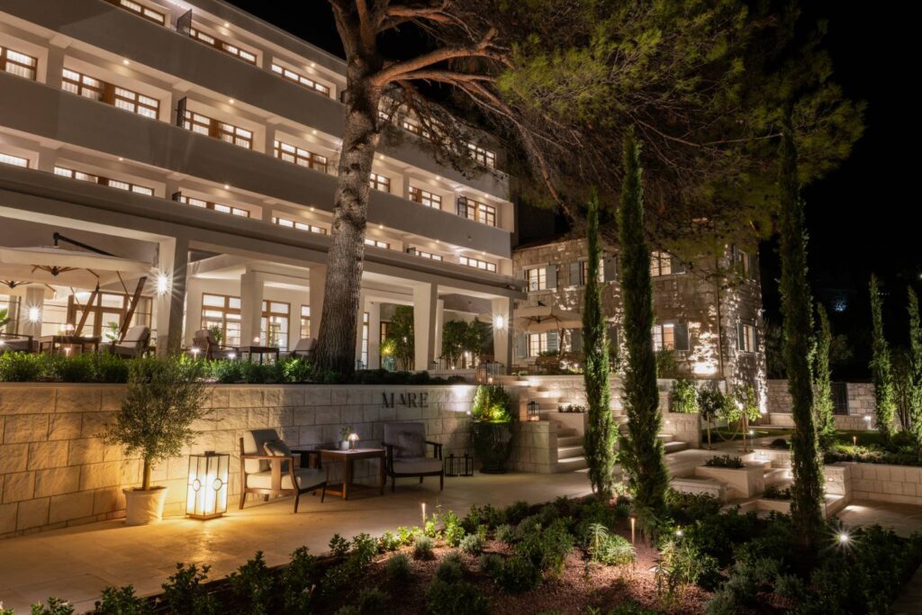 The Bristol Bol lit up at night among pine trees in Bol, Croatia