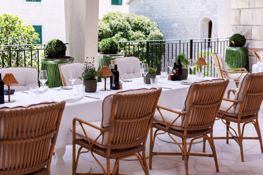 Outdoor dining terrace with rattan chairs at The Bristol Bol, Brac