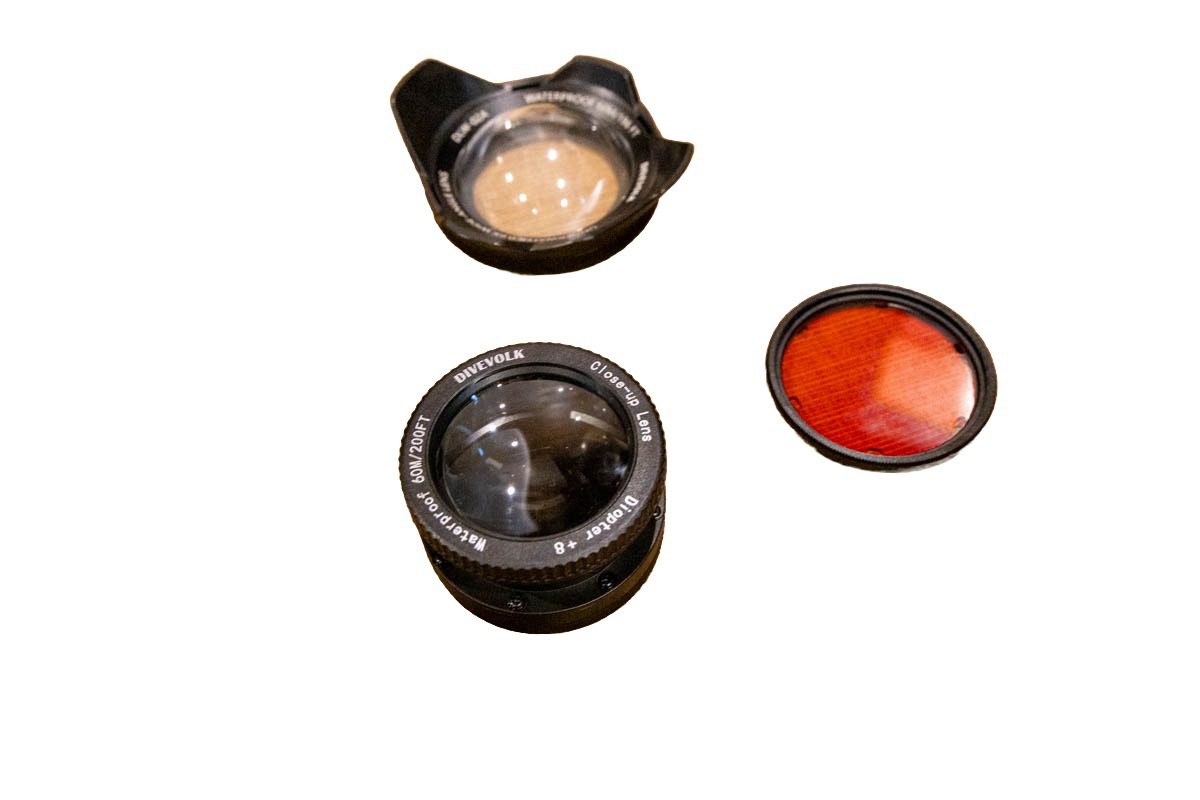 DIVEVOLK accessories on a white background: the 0.6x wide-angle wet lens, the +8 close-up macro lens and the 67 mm red filter