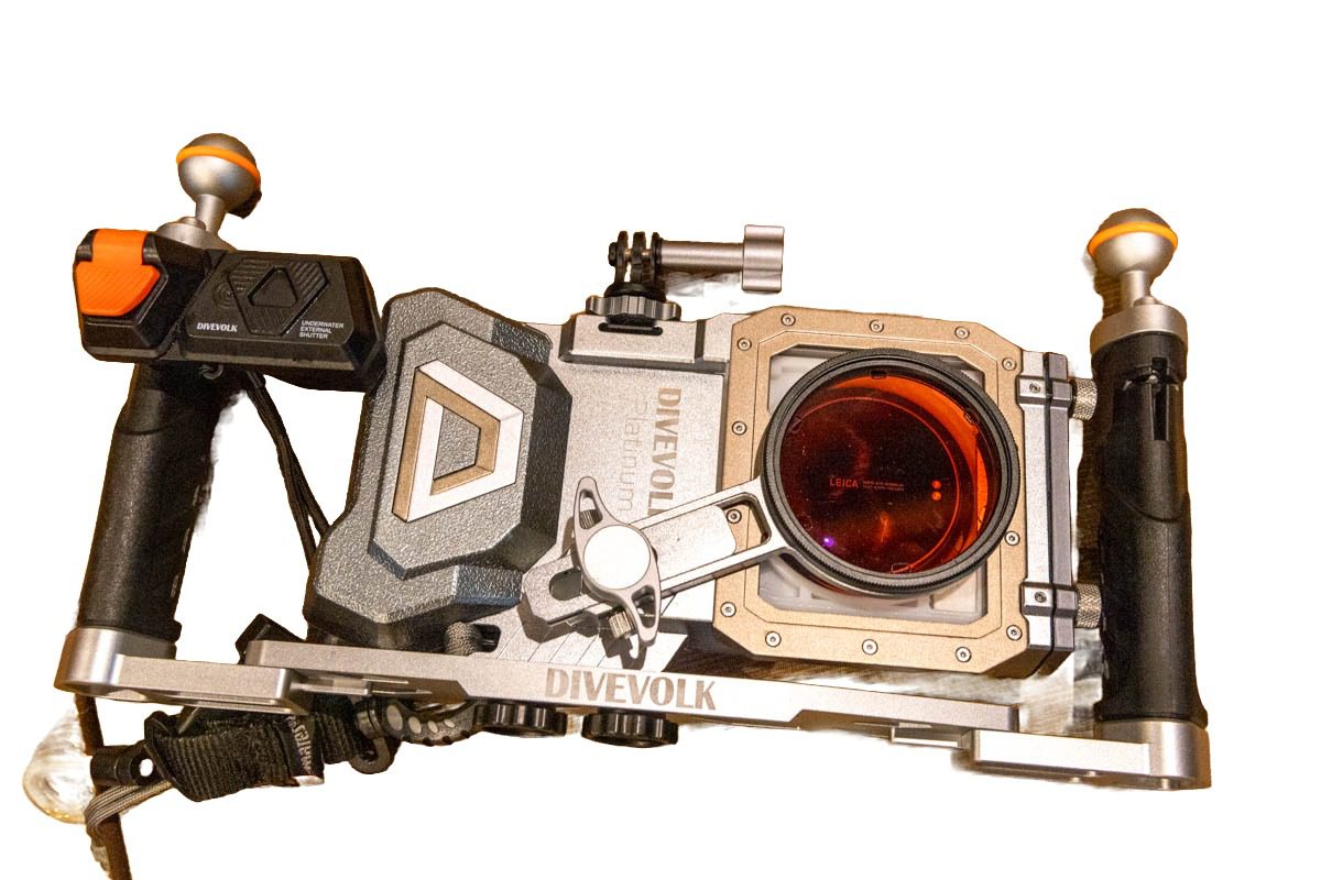 DIVEVOLK SeaTouch 4 Max Platinum V2 aluminum underwater phone housing seen from the front, with a red color-correction filter on the lens port, dual-handle tray and cold-shoe mount