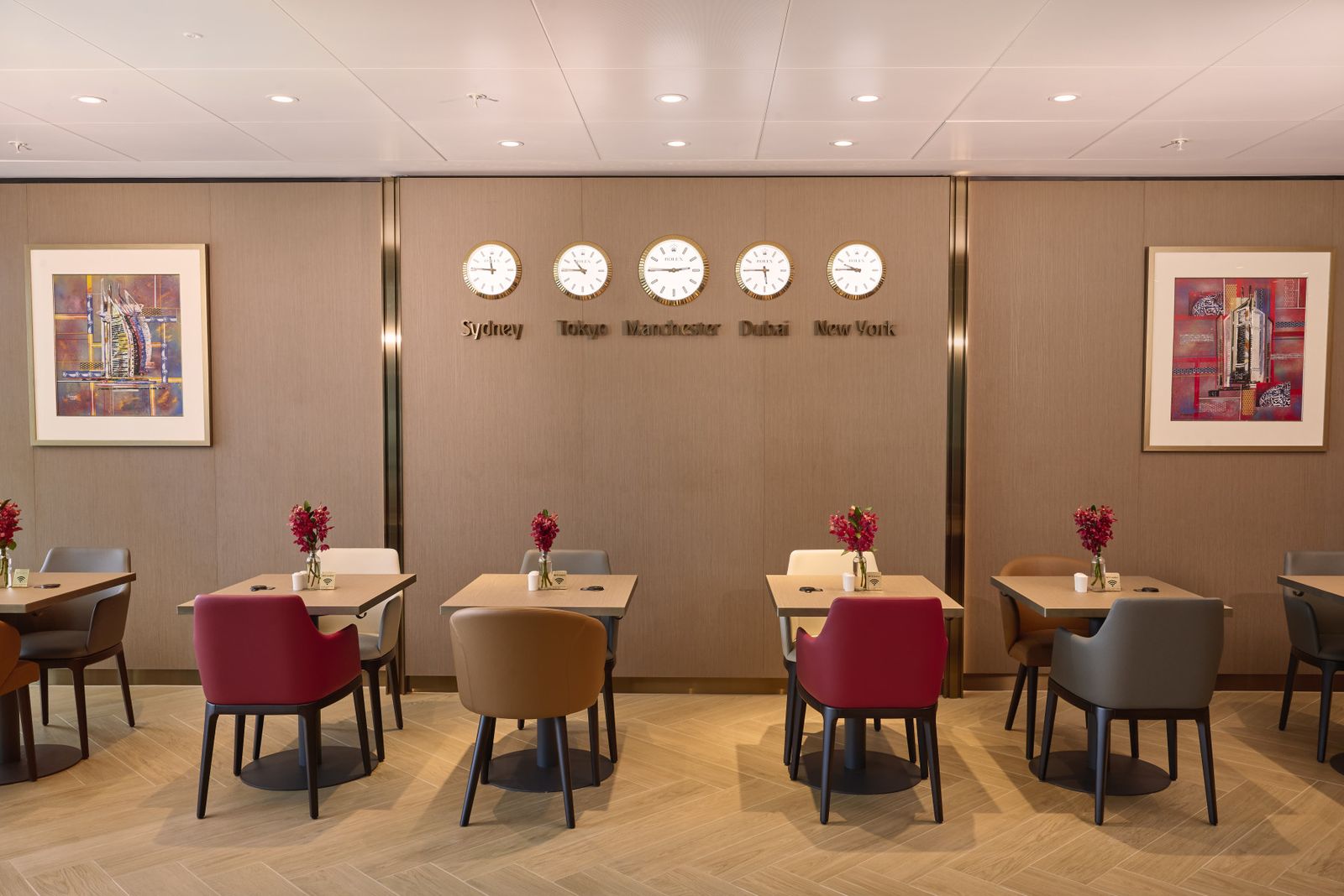 Dining area of the Emirates new lounge at Manchester Airport Terminal 2, with tables and world clocks on the wall
