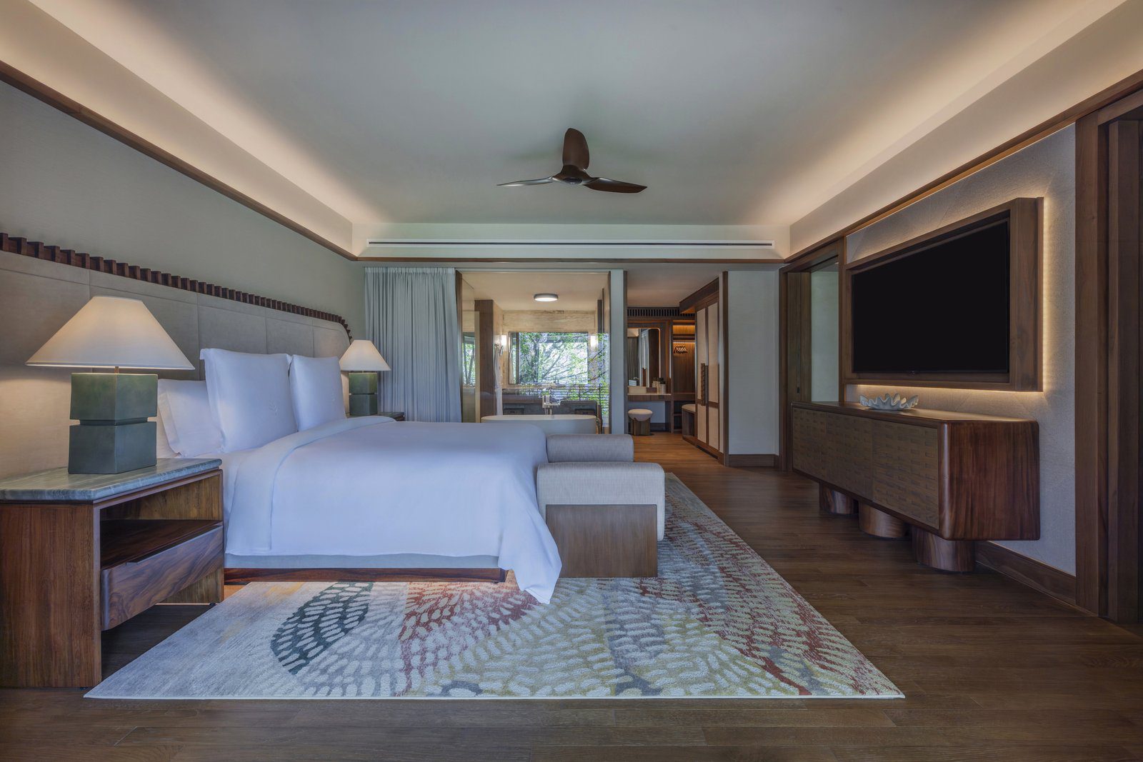 King bedroom of a new Papagayo Suite at Four Seasons Resort Costa Rica with wood cabinetry and a view toward the bathroom