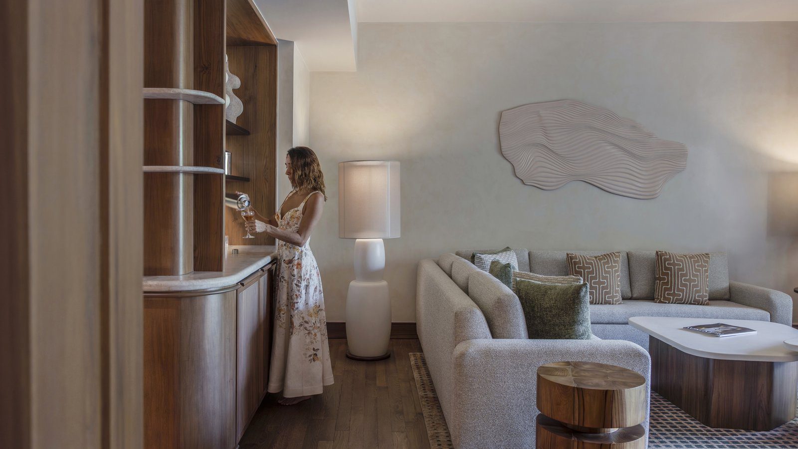 Living room of a new one-bedroom Papagayo Suite at Four Seasons Resort Costa Rica with a corner sofa and wood cabinetry