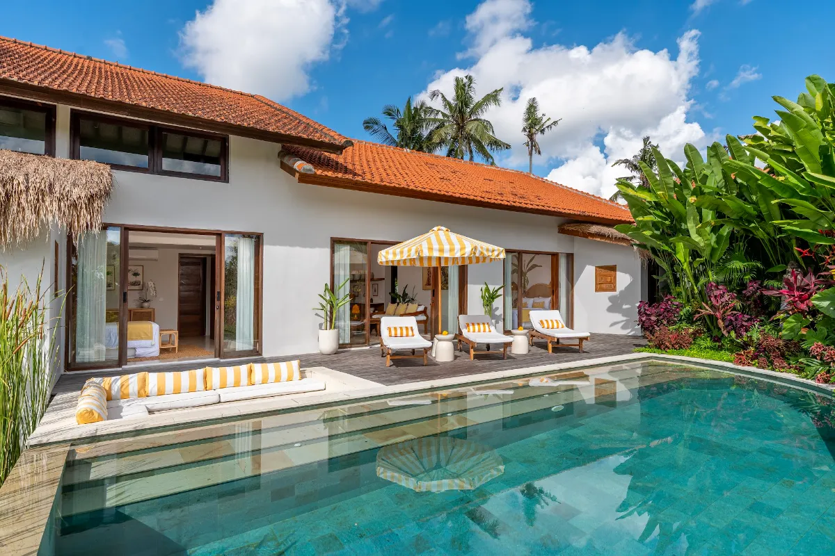 Private pool villa at Goddess Retreat Ubud with sun loungers, striped umbrella and tropical garden