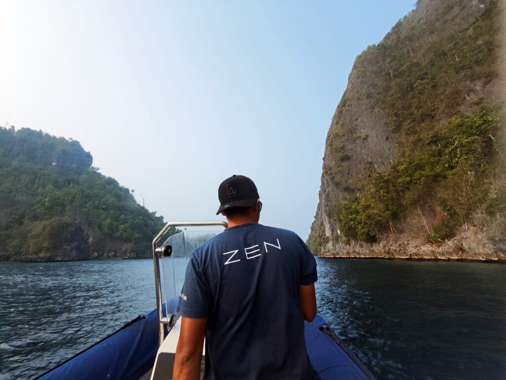 Snorkel guide Agung driving the Scubaspa Zen snorkel speedboat between the karst islands of Misool, Raja Ampat
