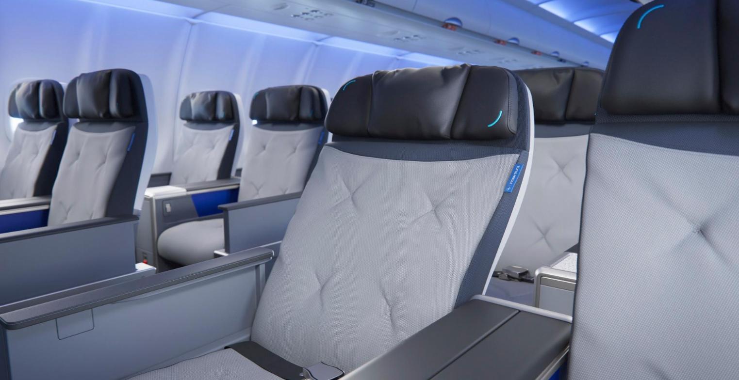 Close view of a reclined JetBlue BlueFirst seat with quilted grey Tuft and Needle cushioning and a black leather headrest