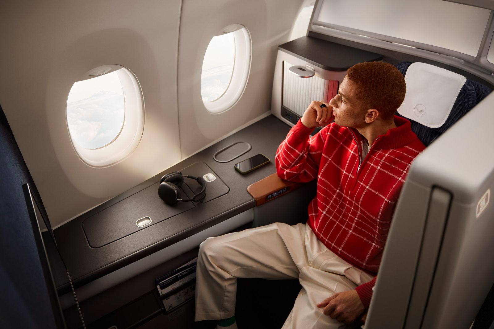 Passenger in a Lufthansa Allegris Business Class single suite by the window