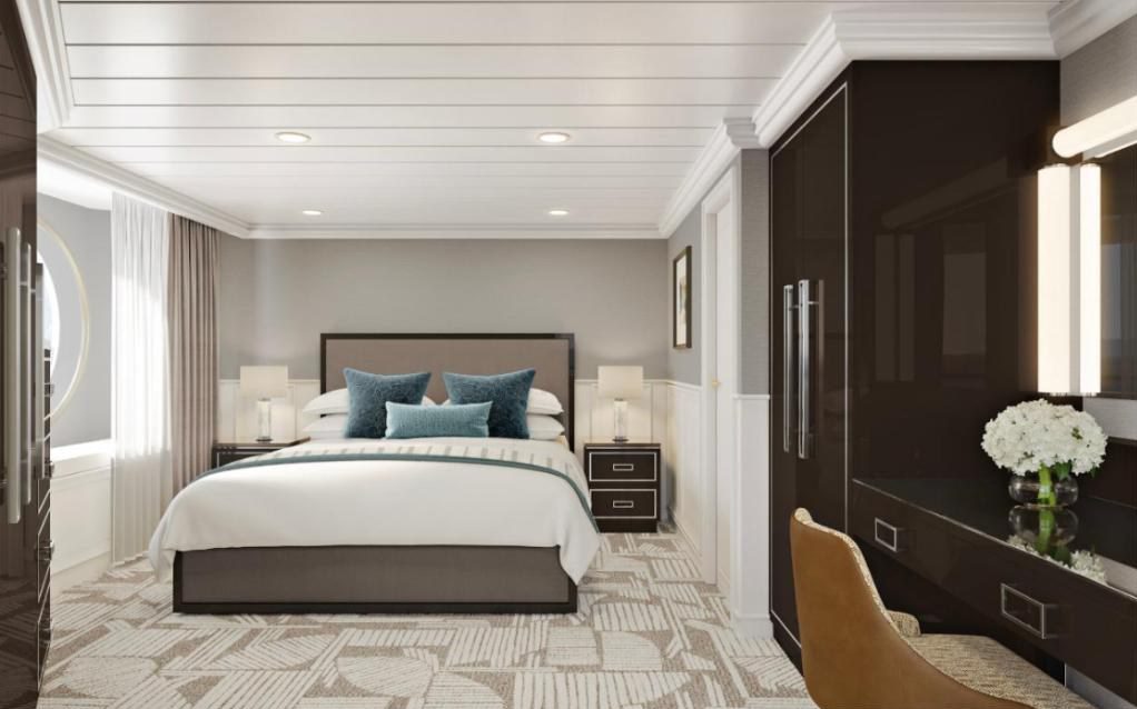 Rendering of a suite bedroom on Oceania Aurelia with a king bed, teal cushions and dark wood wardrobes