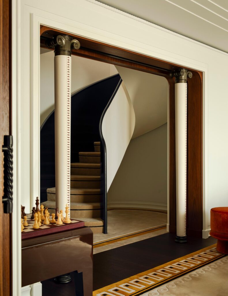 Inside a Duplex Suite on Orient Express Corinthian, with a curving staircase behind lacquered wood doors
