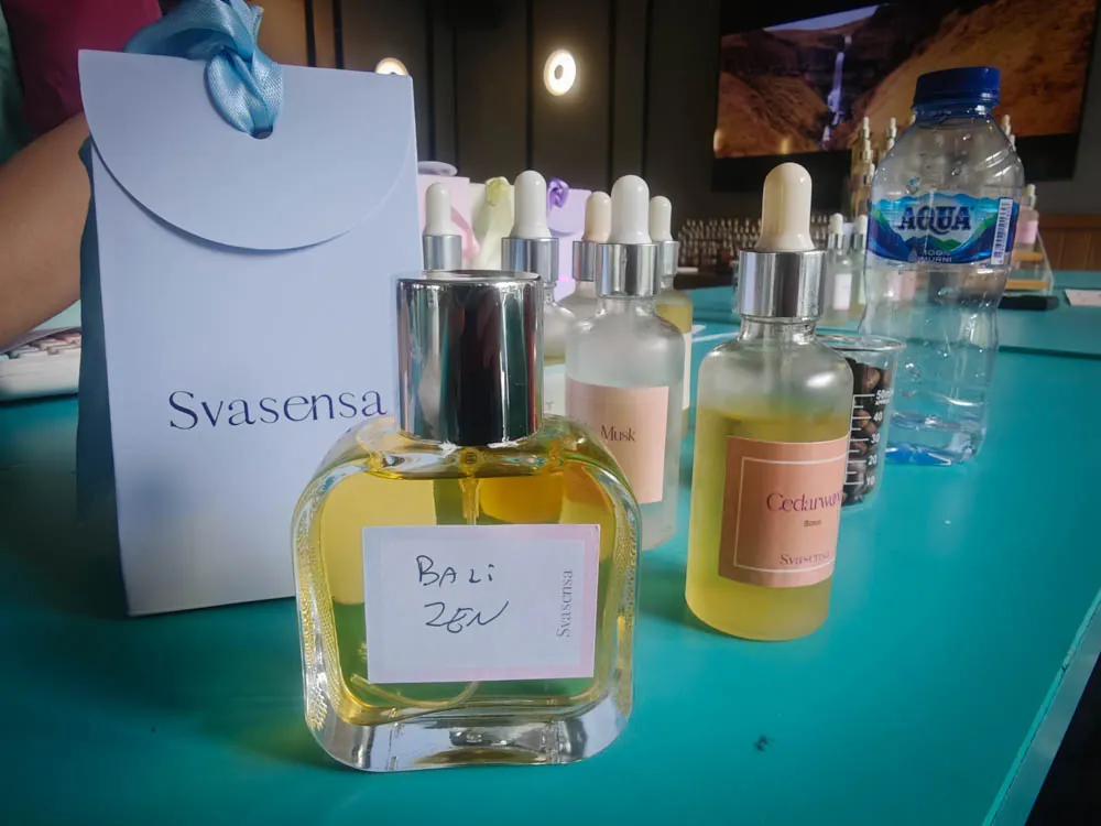 Bottle of custom perfume from the Svasensa perfume-making workshop next to sample bottles and a gift bag