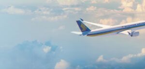 Singapore Airlines Airbus A350-900 in flight above the clouds, showing the blue tail and gold bird logo