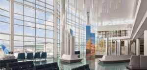 Interior of United’s new Terminal B North Concourse at Houston Bush Intercontinental, with floor-to-ceiling windows, gate B10 seating, The Digital Bayou light installations and a United aircraft outside