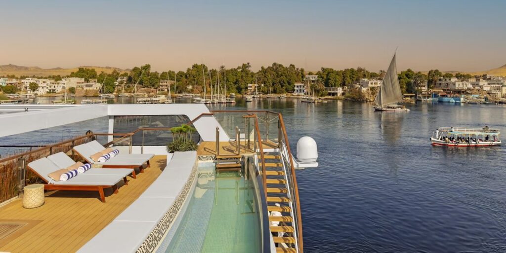 Pool and sun loungers on the top deck of Viking Aton, a Nile sister ship of Viking Sekhmet, at dusk on the river